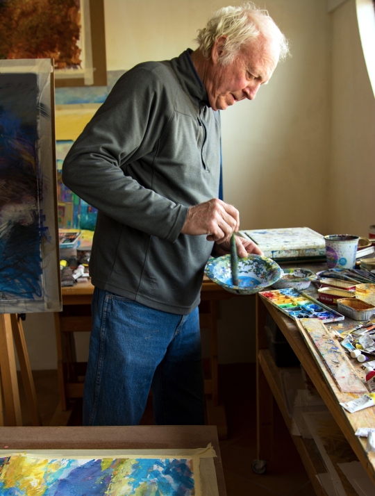 An artist painting in studio.